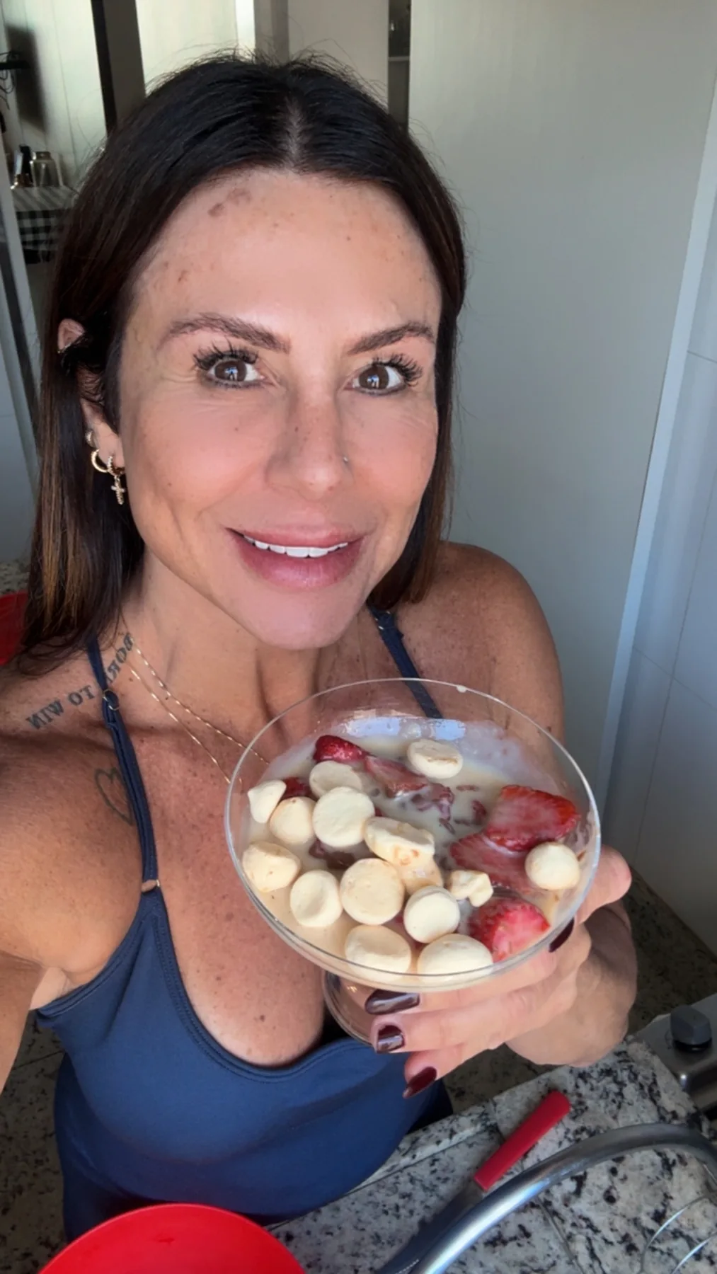 Dani Moraes mostrando uma tigela com morangos e sobremesa